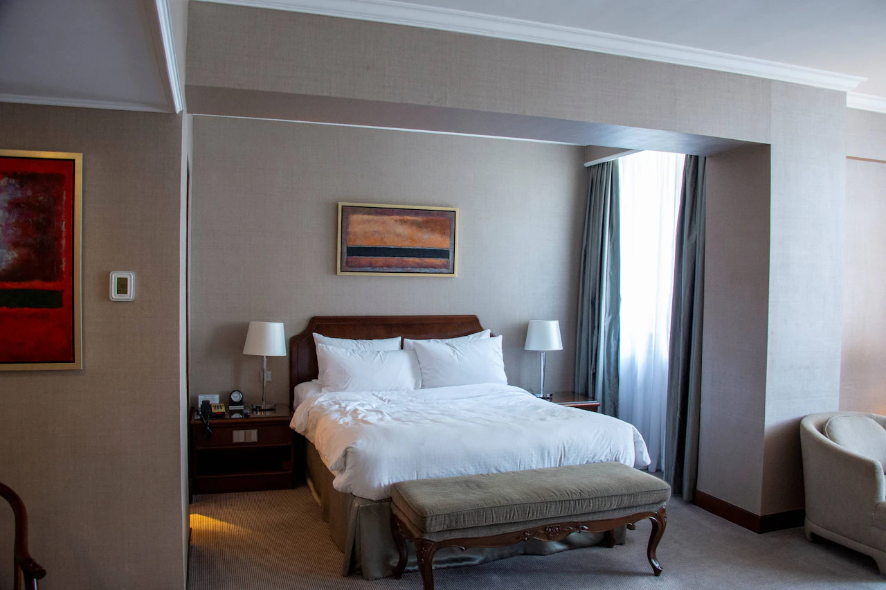 Double bed, bedside lamps and a window in a hotel room