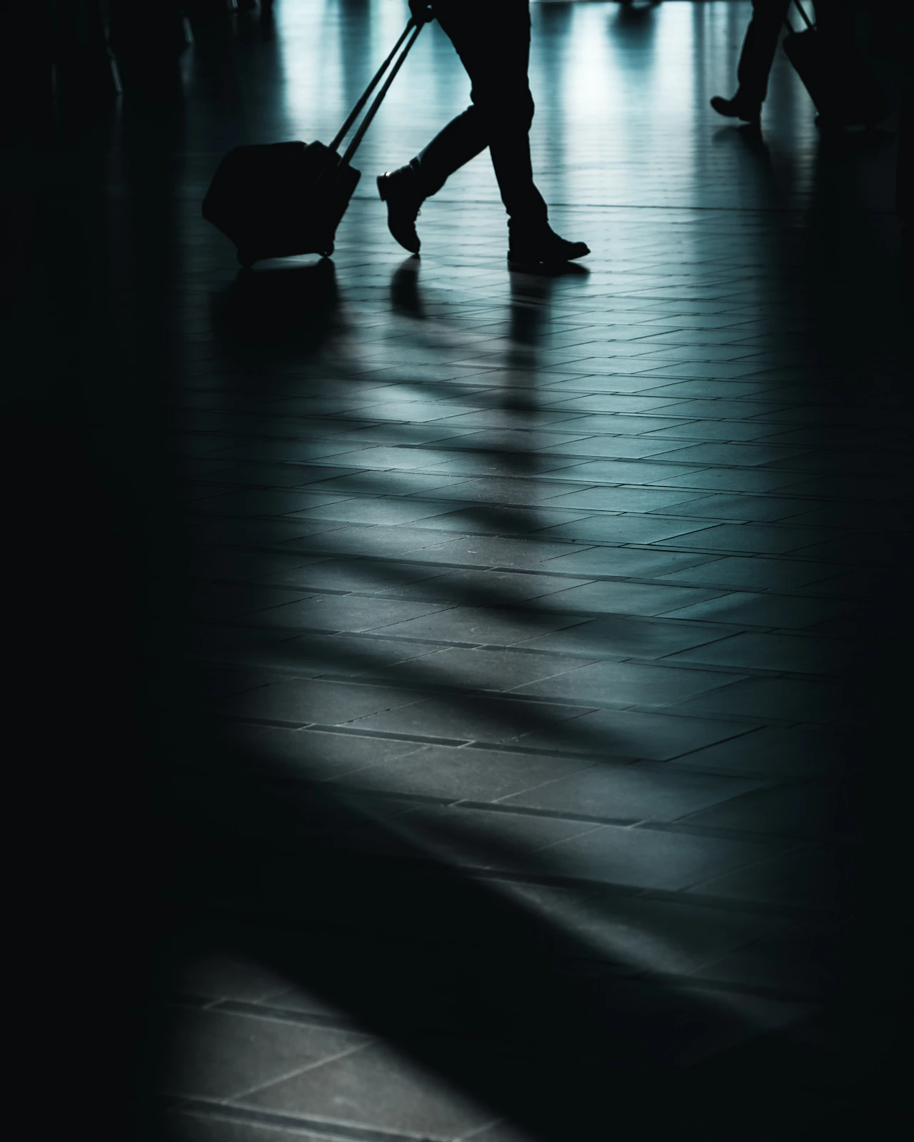 Traveller walking through an airport terminal with a wheeled suitcase