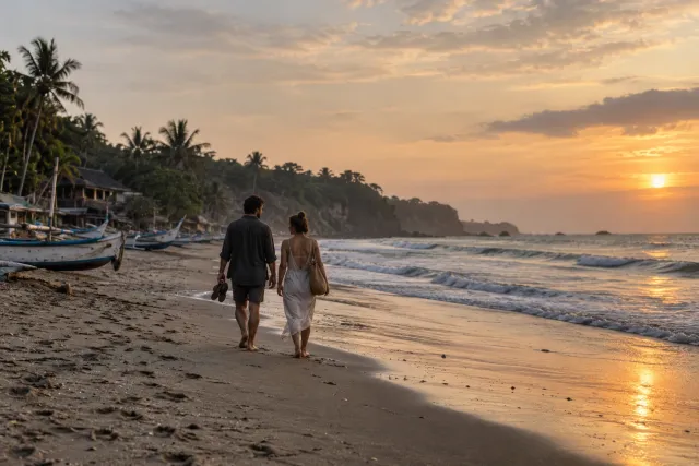 Two travellers enjoying a quiet walk on the beach at sunset